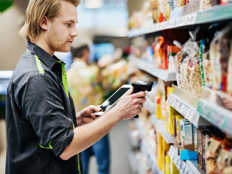 A man scanning a product's code inside a grocery store