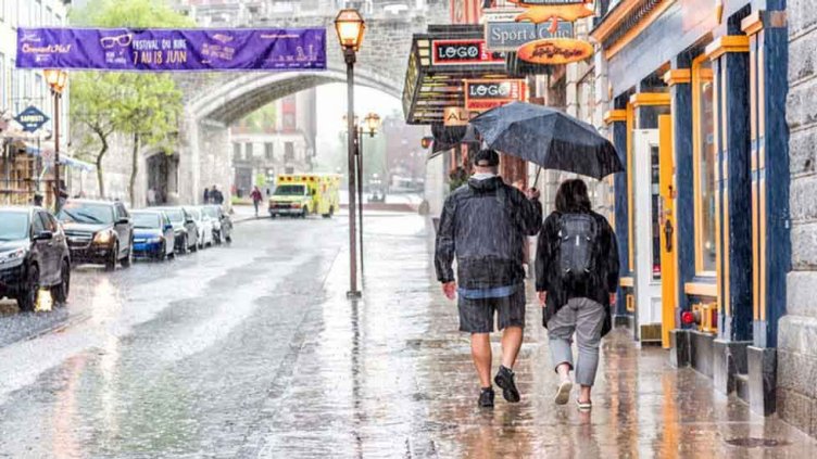 Two people going somewhere in the rainfall holding umbrella 