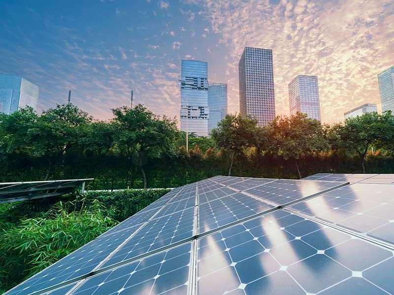 Solar Power Plant in modern city in sunset