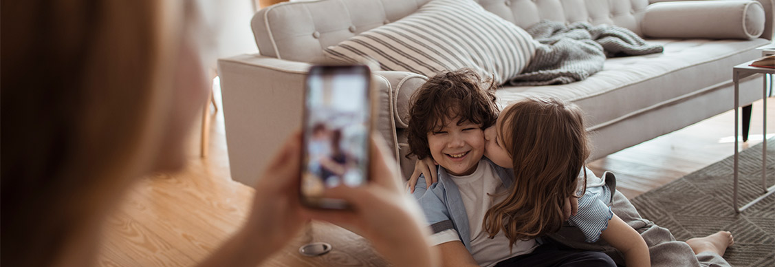 A mother taking pictures of her kids at home