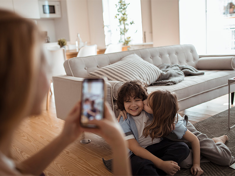 A mother taking pictures of her kids at home