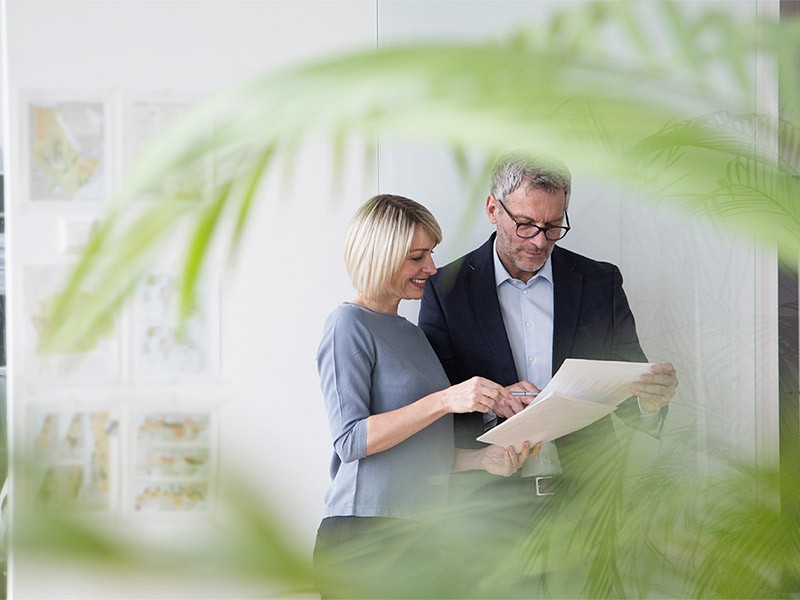 Businessman and woman working together in office discussing documents