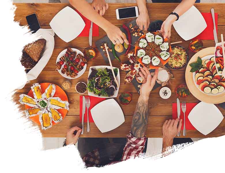 peoples sitting on the table and eating the different kind of food 