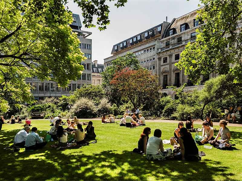 People relaxing in urban green space on a sunny day