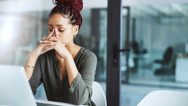 woman looking stressed out while working in an office