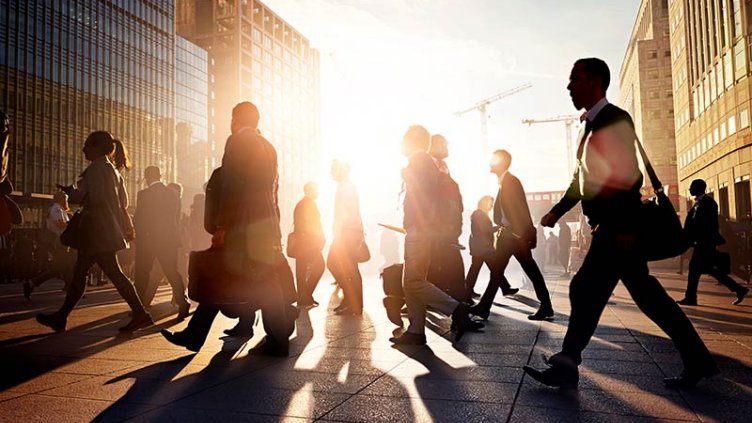 Commuters walking to work in the city at sunrise