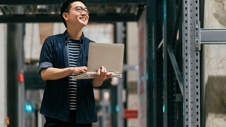 A man holding Laptop and looking