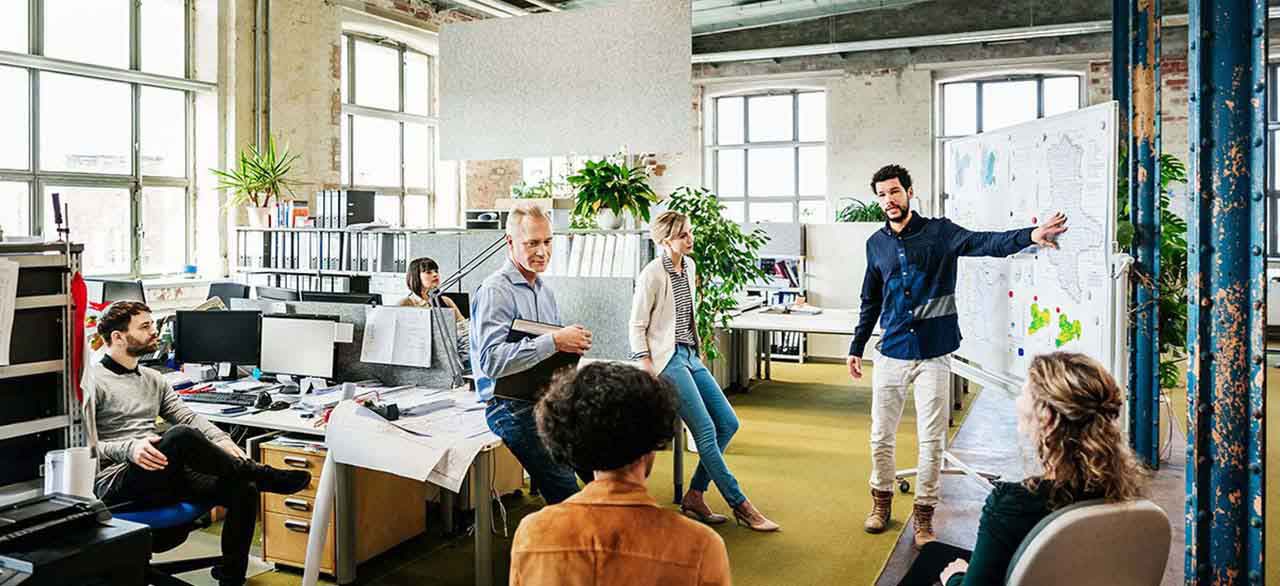 Office manager addressing his team in office workspace